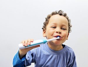 a child brushing with an electric toothbrush