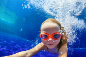 a child swimming during the summertime