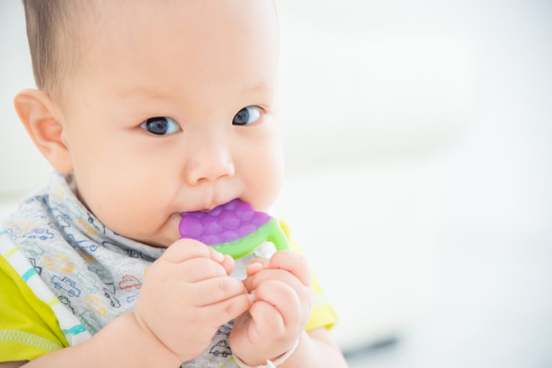 Baby teething on a toy