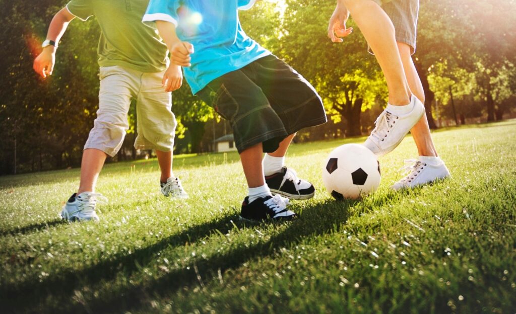 kids playing soccer in field