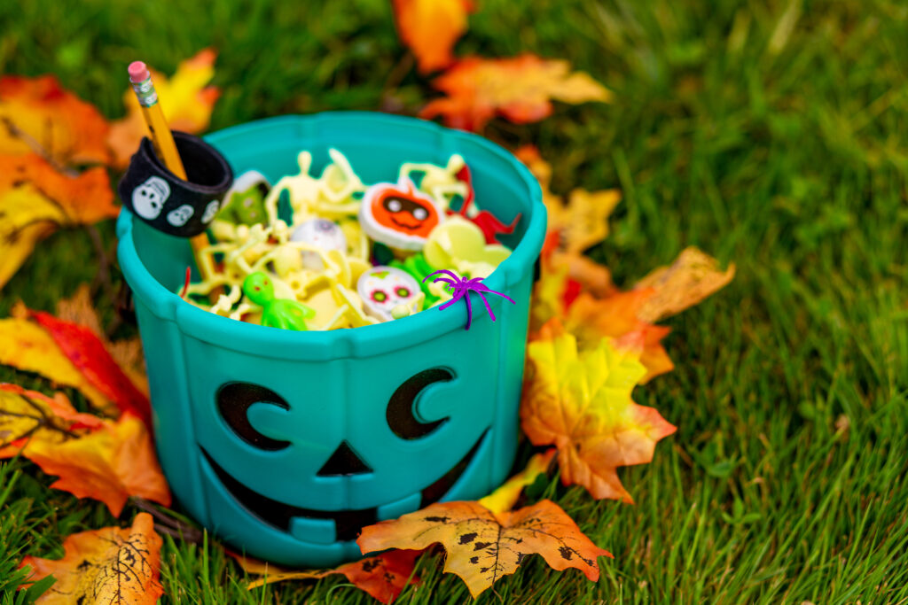 A teal pumpkin pail on the ground